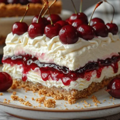 Cherry Yum Yum No-Bake Dessert with graham cracker crust, creamy cheesecake layer, and cherry topping in a glass dish