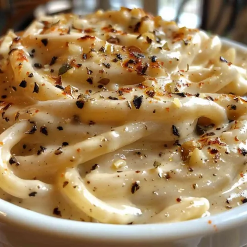 Dairy Free Alfredo Sauce – Creamy Every Time, No Dairy 6 Close-up of extra creamy dairy free Alfredo sauce coating pasta, topped with cracked black pepper and seasonings.